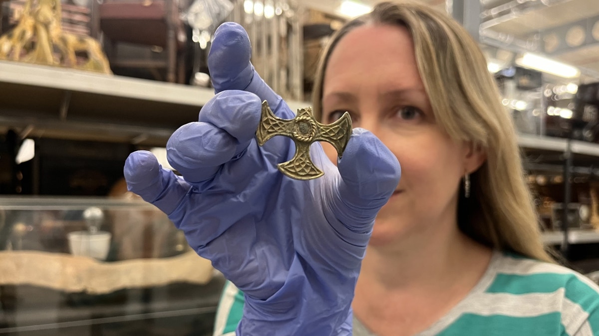 Curator holding broken cross