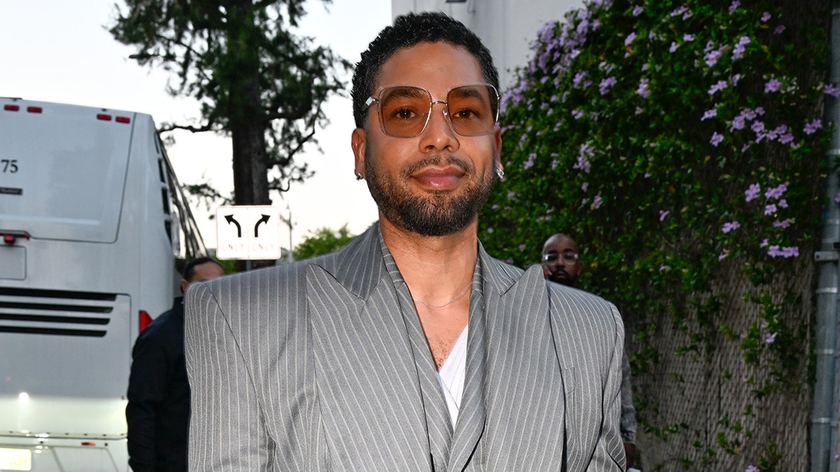 Jussie Smollett in a gray suit and sunglasses