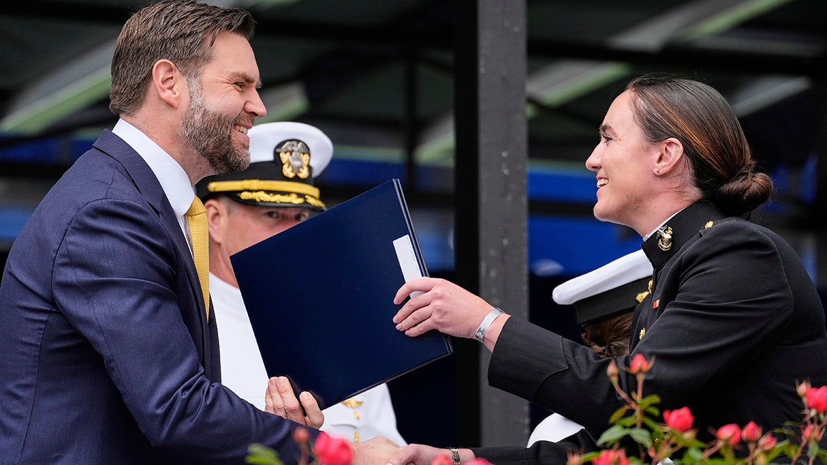 JD Vance hands a diploma