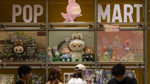 Getty Images Customers browse a Pop Mart display filled with Labubu characters and collectible figures from The Monsters series on June 16, 2025 in Chongqing, China. 