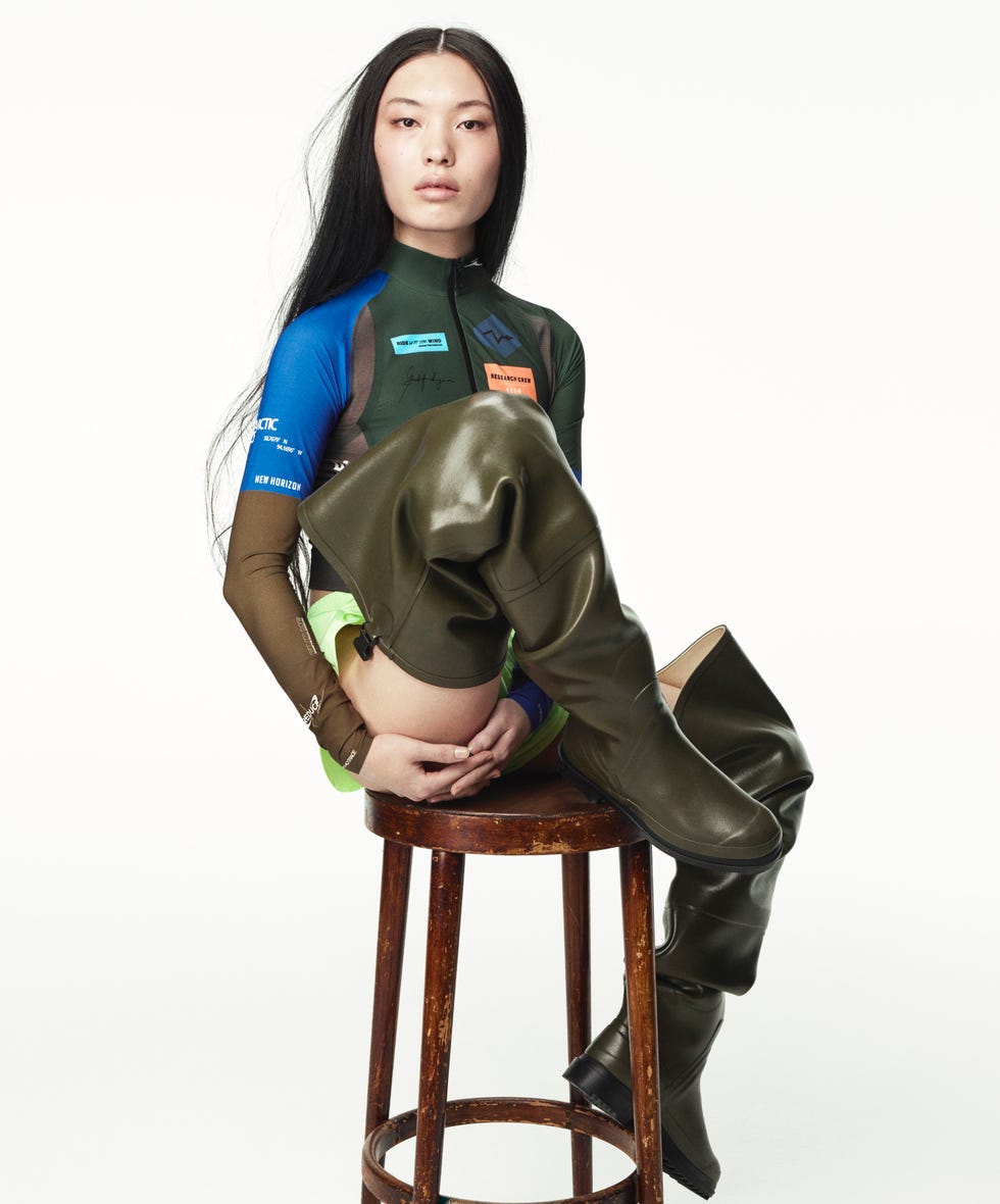 stylized fashion model seated on a stool showcasing unique outfit elements