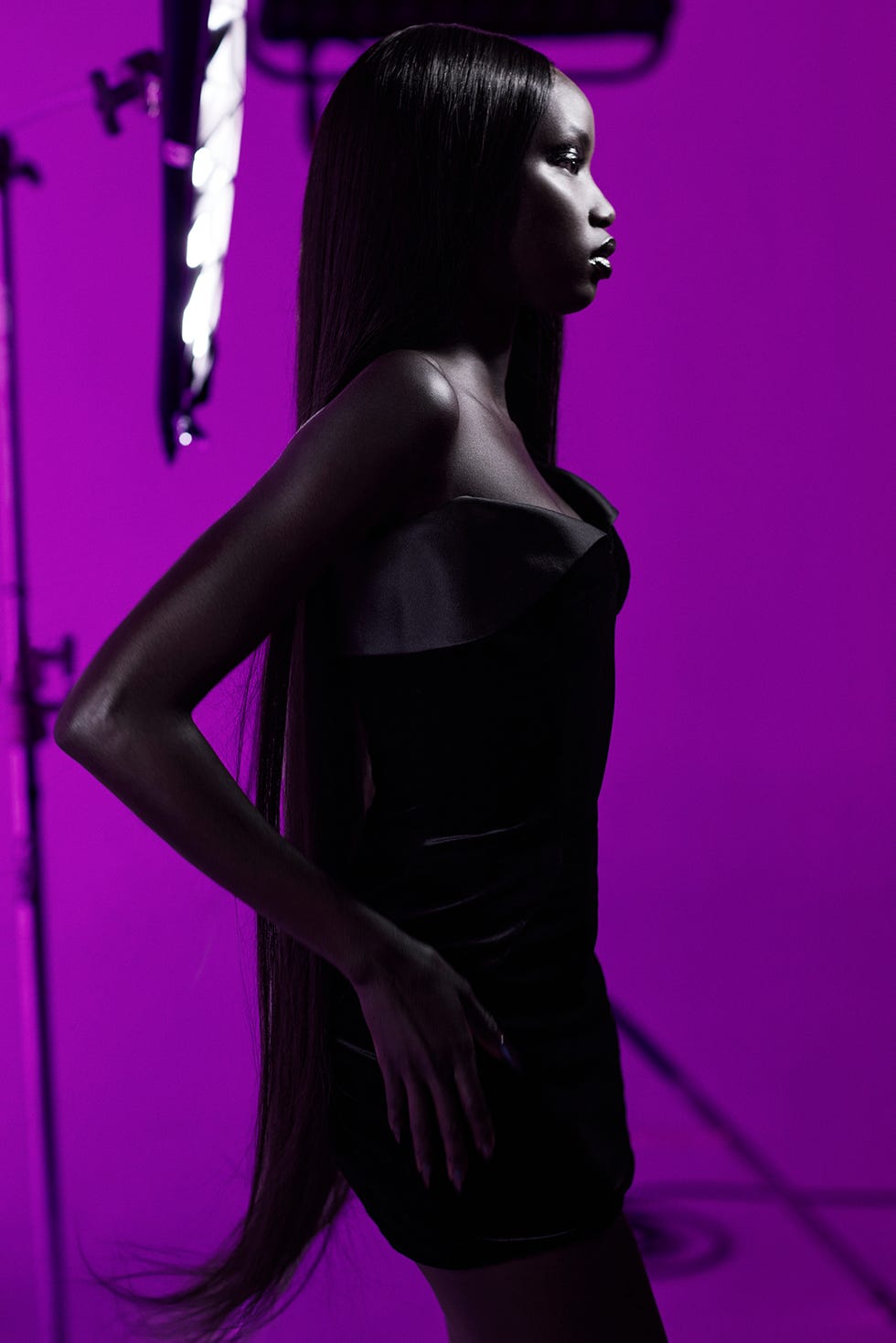 silhouette of a person in a black dress against a colored backdrop