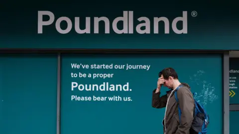Getty Images A man with his hand to his forehead passes down the signage of a temporarily closed branch of Poundland in Southport, UK, 2024.