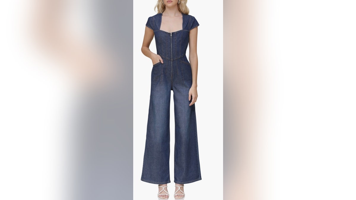 A model wearing a wide-leg denim jumpsuit on a white background