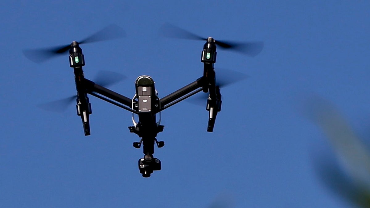 A drone flies in blue skies