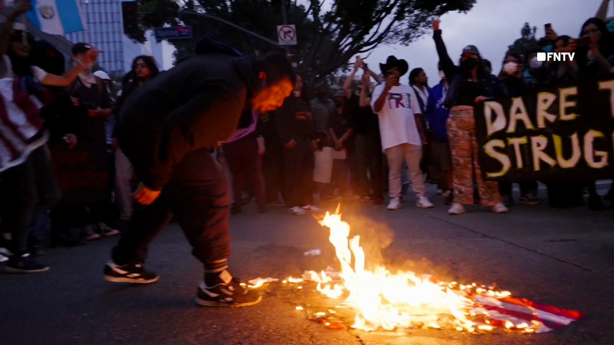 A man spits on a burning American flag in Los Angeles.