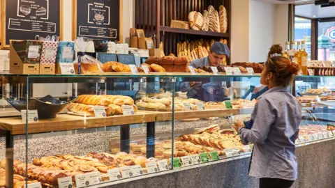 Paris Baguette Customer looking at bread inside a Paris Baguette outlet in France.