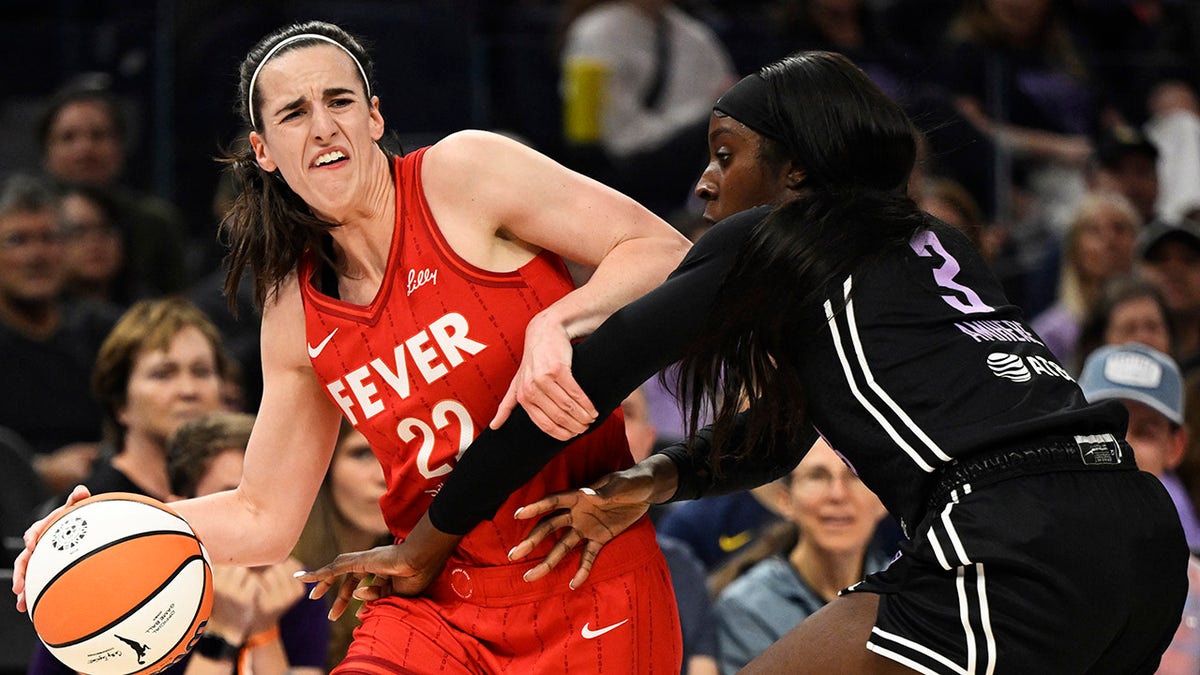 Caitlin Clark battling defender