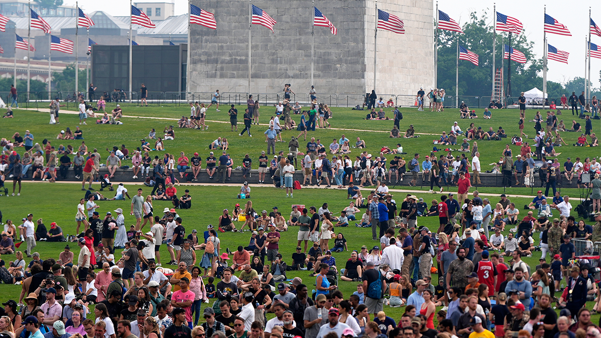 People on the lawn around the Washington Monument as President Donald Trump attends a military parade commemorating the Army's 250th anniversary on Saturday, June 14, 2025, in Washington.