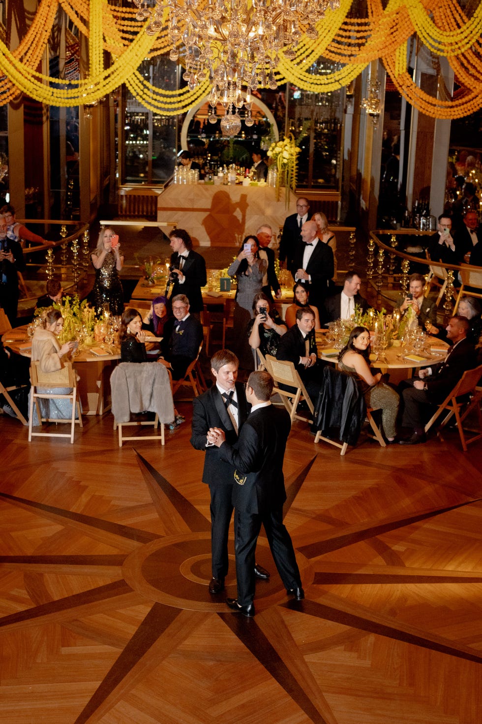 two grooms dance on a grand dance floor