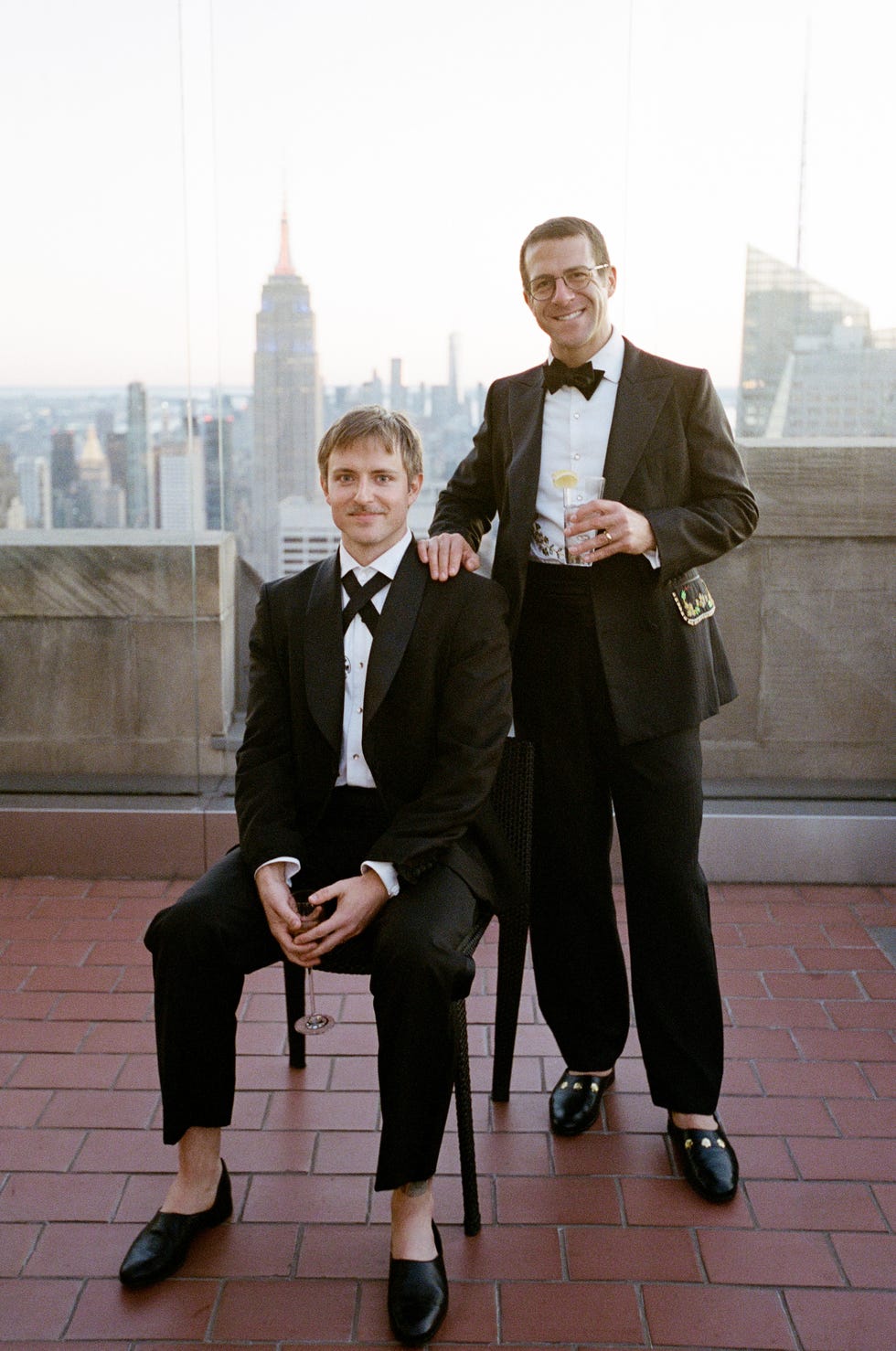 two grooms stand with a view of the new york city skyline
