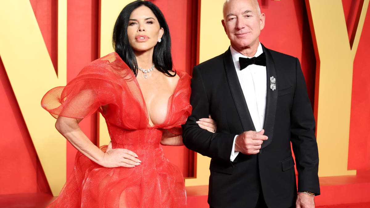Lauren Sanchez in a red gown with Jeff Bezos in a tuxedo on red carpet