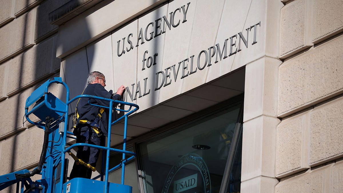 USAID building, man taking down letters