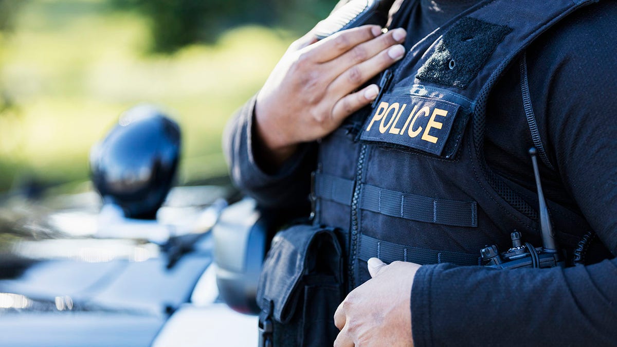 police officer with hand on police vest