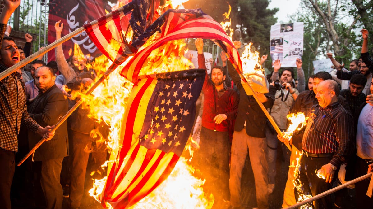 demonstnrators burning US flags