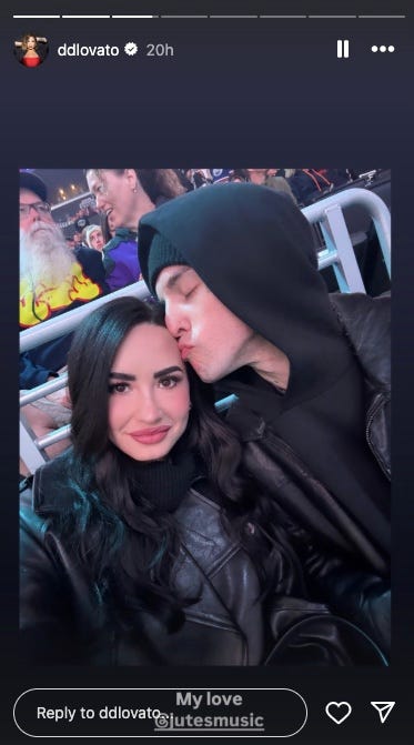 two individuals enjoying an event dressed in dark clothing