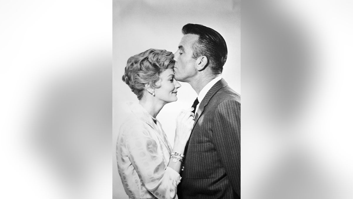 Hugh Beaumont kissing Barbara Billingsley on the forehead.