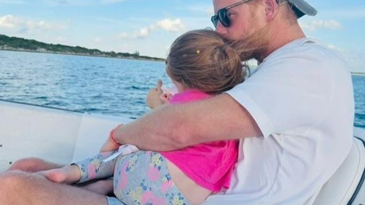 Princess Lilibet cradled by Prince Harry