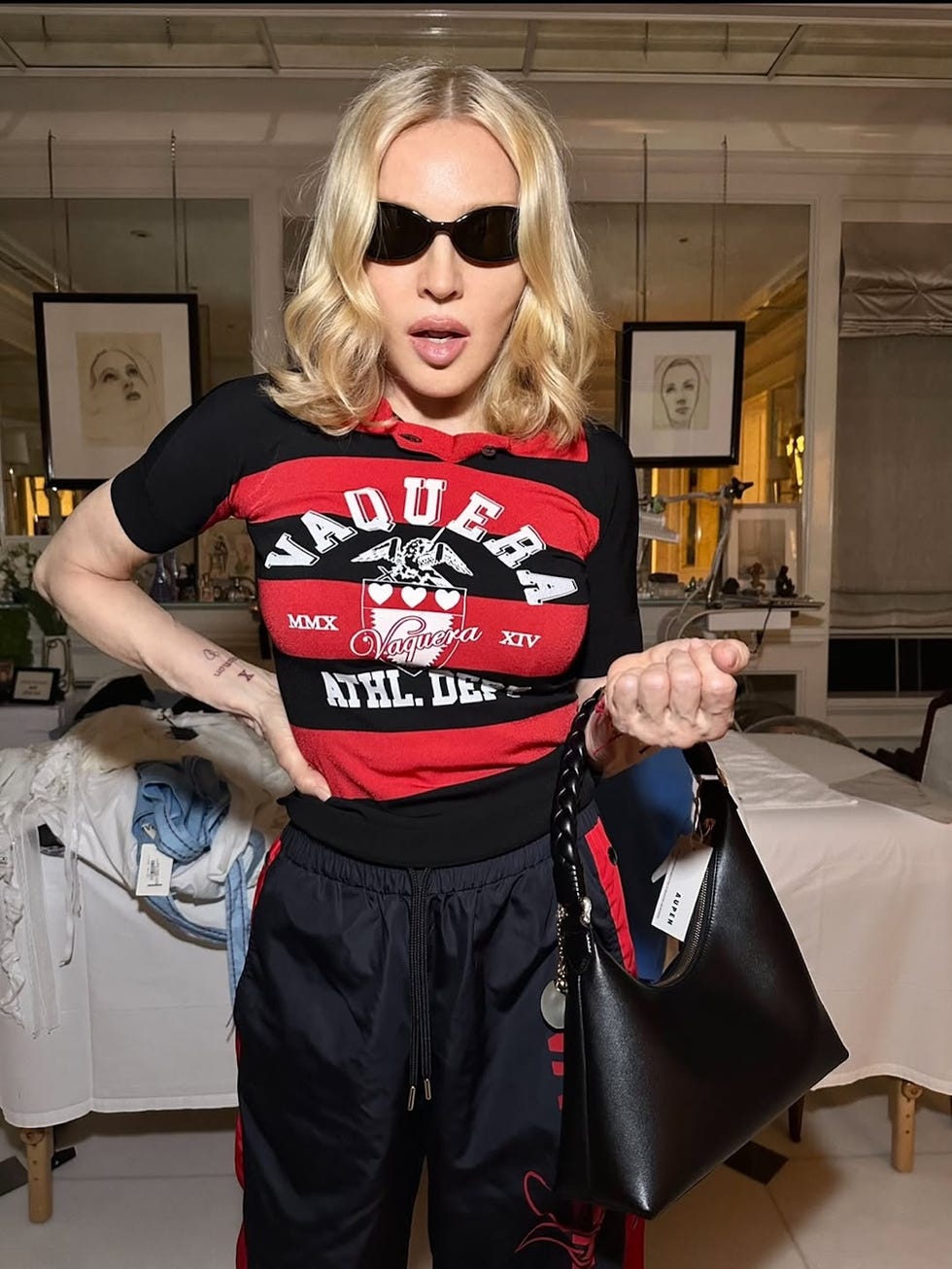 person wearing a red and black outfit holding a black handbag