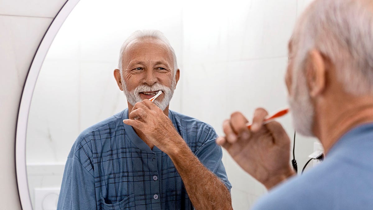 Senior man keeping his dental hygiene in check by brushing