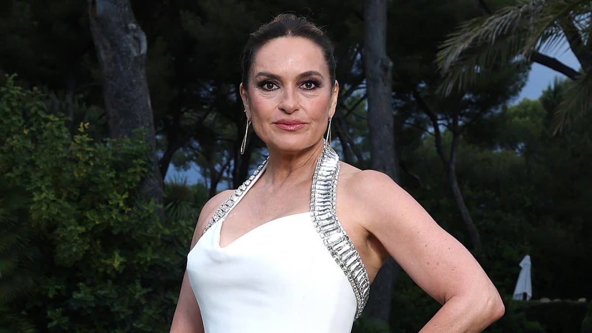 mariska hargitay posing in a white gown on a lawn 