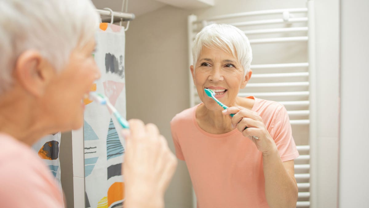 Older woman brushing teeth