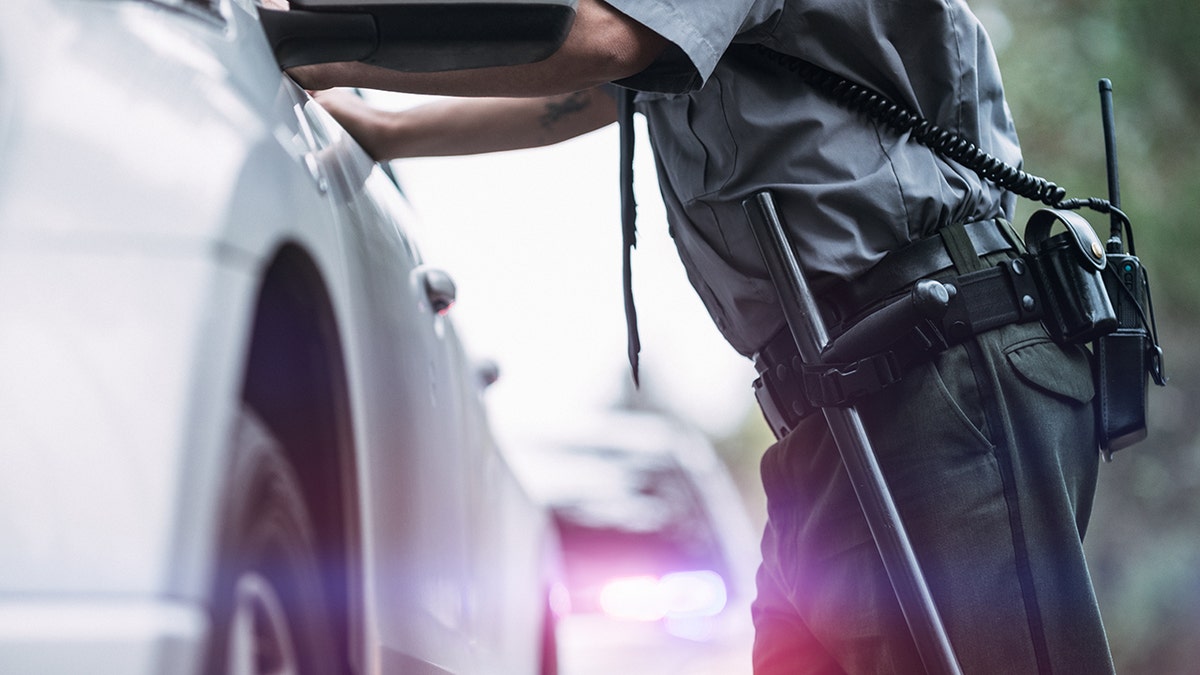 Police officer standing outside driver's vehicle