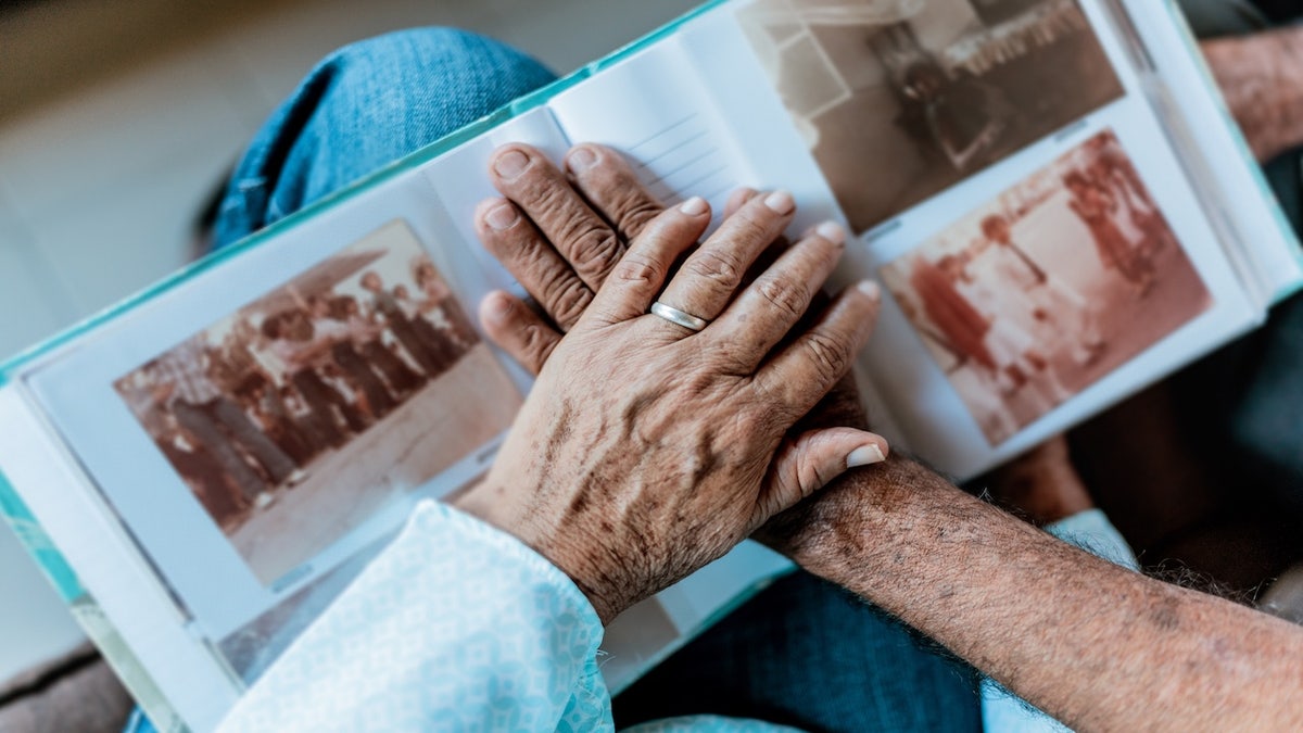 Close-up of couple hands on top of a photo album