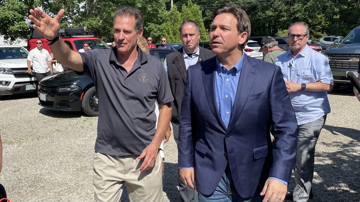 Scott Brown, left, waving, walks with Gov. Ron DeSantis