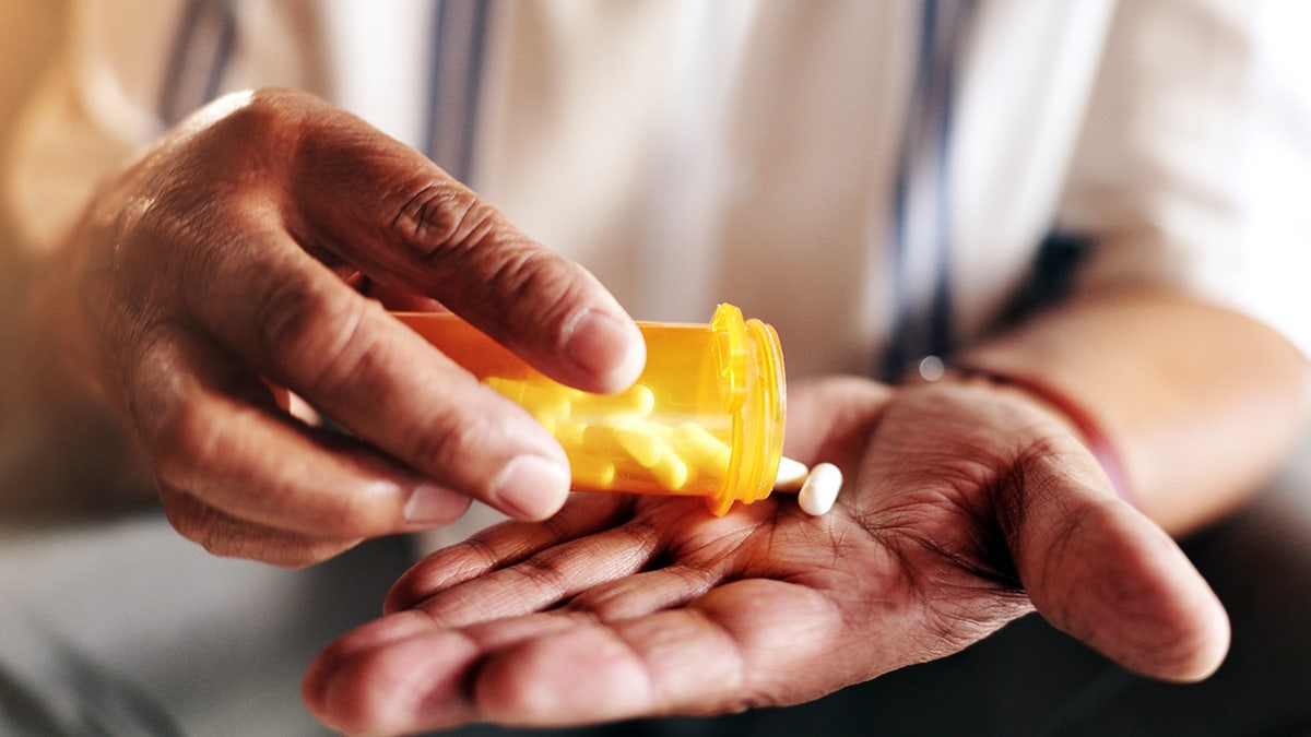 Hands, pills and bottle in closeup for person with drugs, routine and schedule for health in home. Elderly patient, container and pharma product for supplements, wellness or benefits in retirement