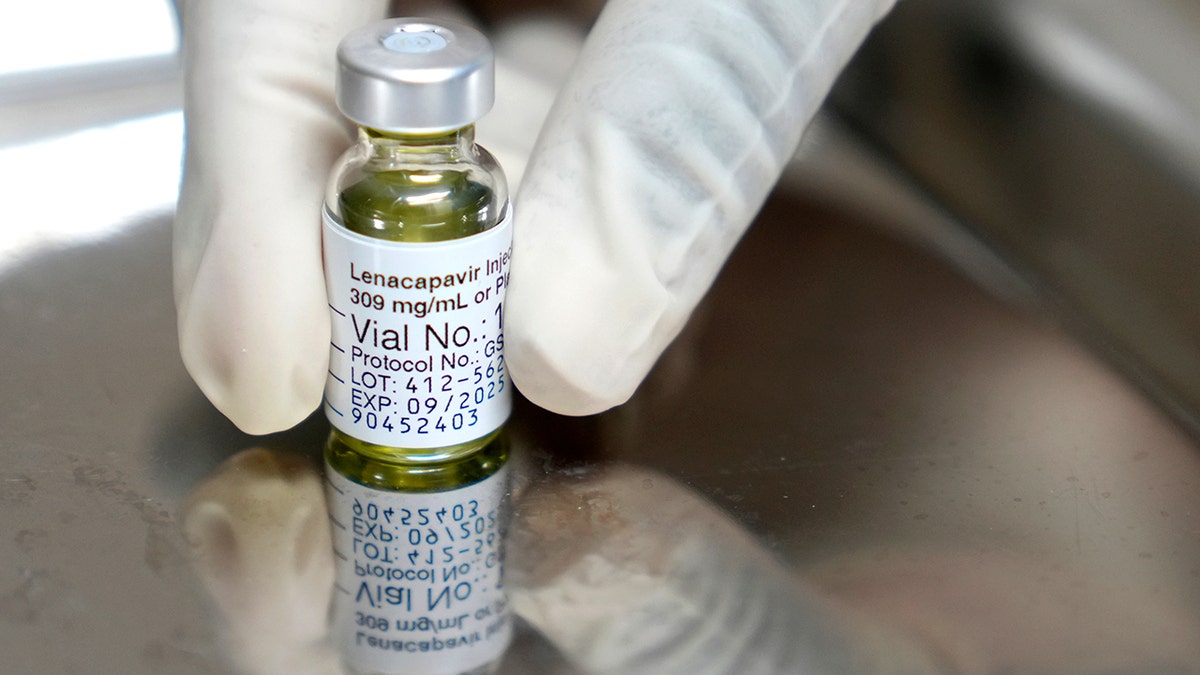 A pharmacist holds a vial of lenacapavir