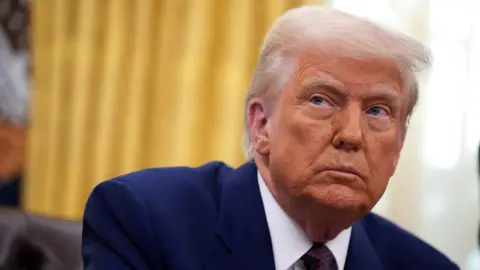 Getty Images US President Donald Trump in a blue suit, looking off at an angle
