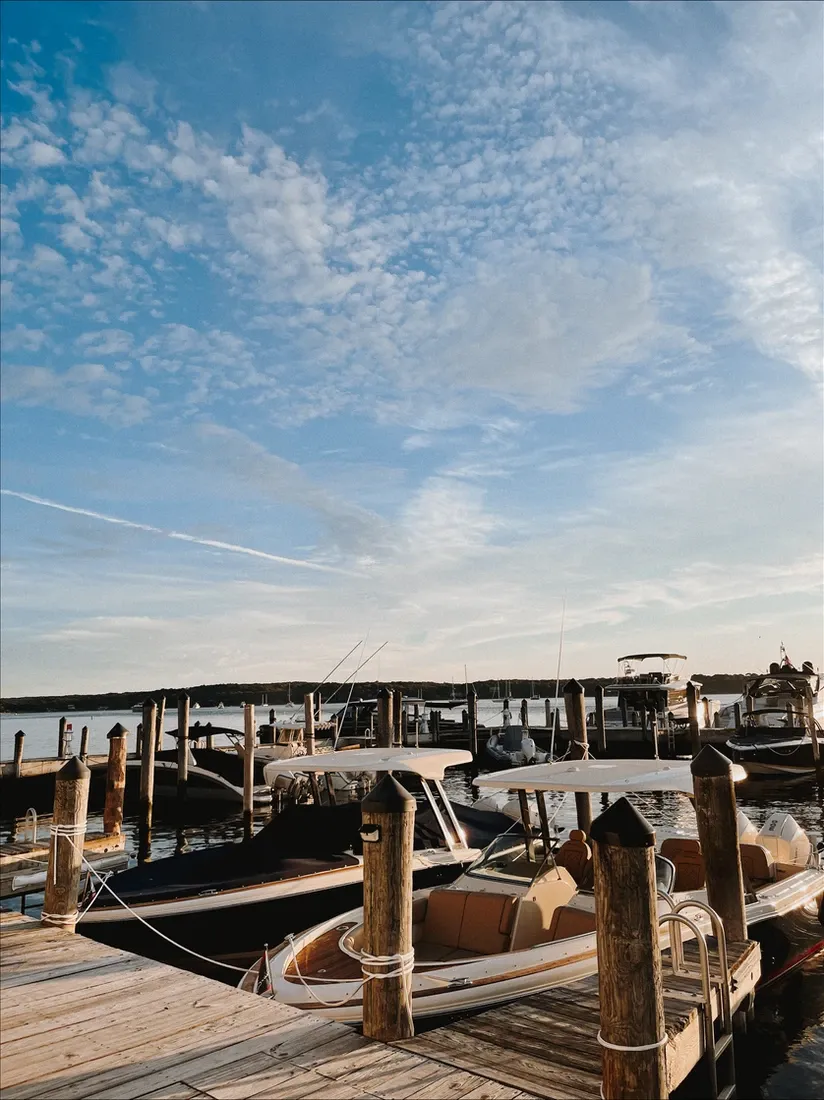 docked boats at a marina under a partly cloudy sky