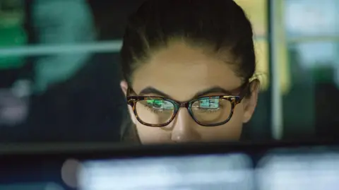 Getty Images Close of of young woman wearing glasses looking at monitor