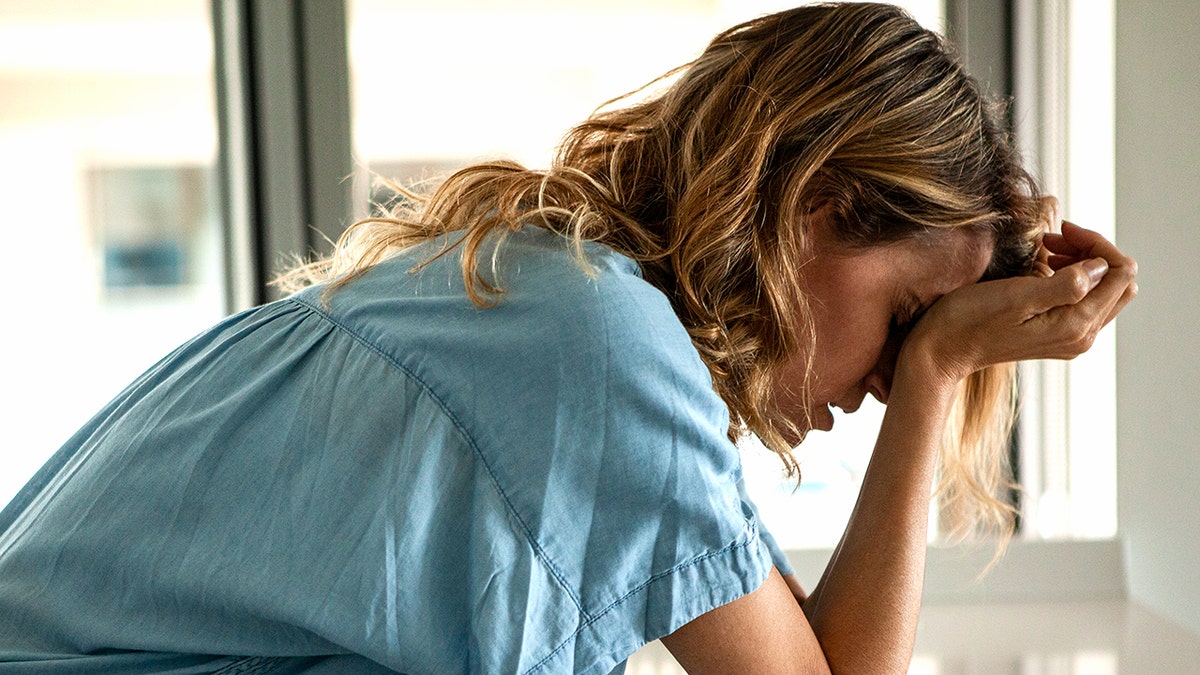 Woman holding her head during a migraine