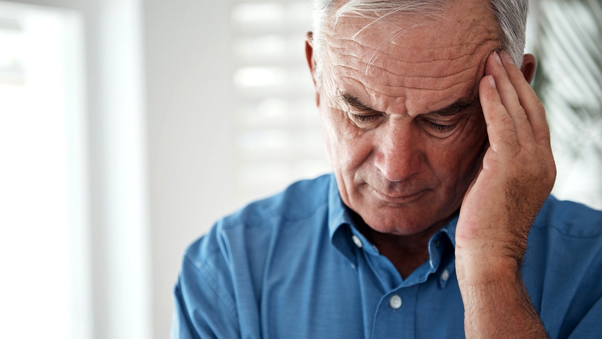 Man holding head during migraine