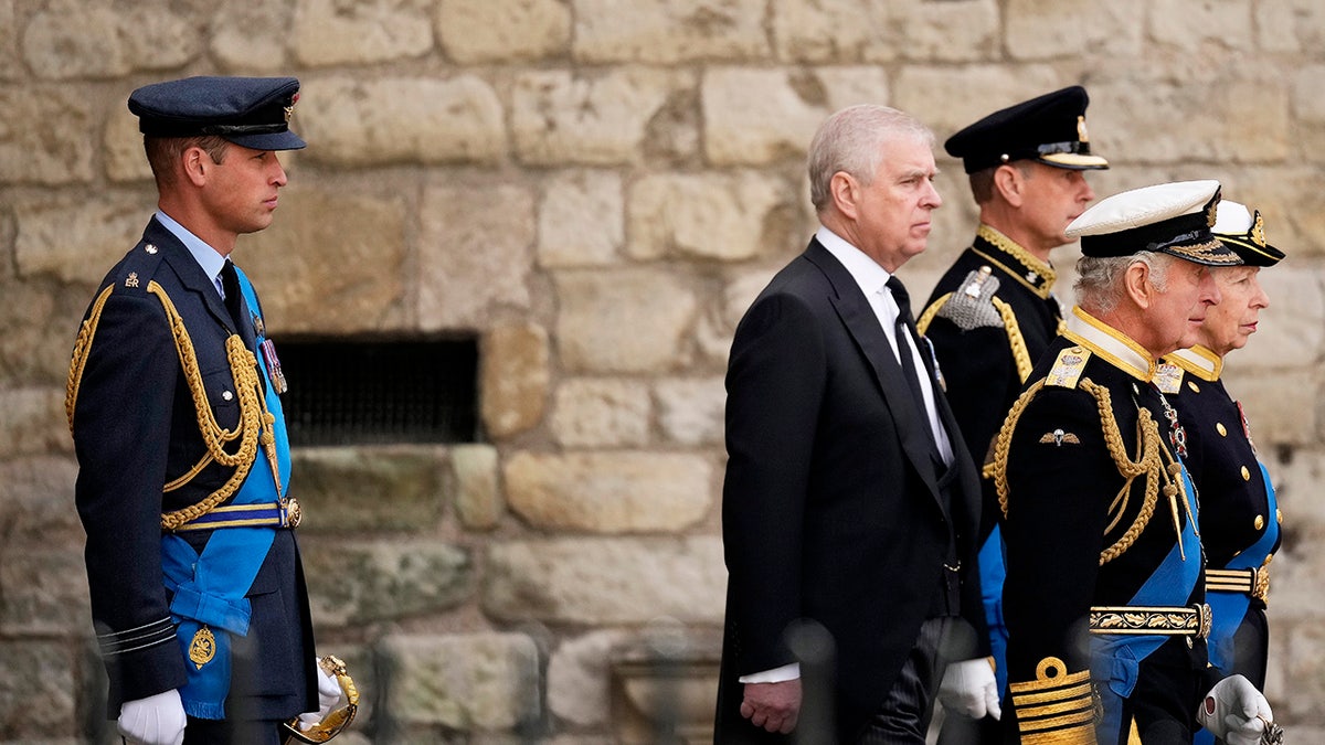 Prince William in uniform standing behind senior royals at a funeral.