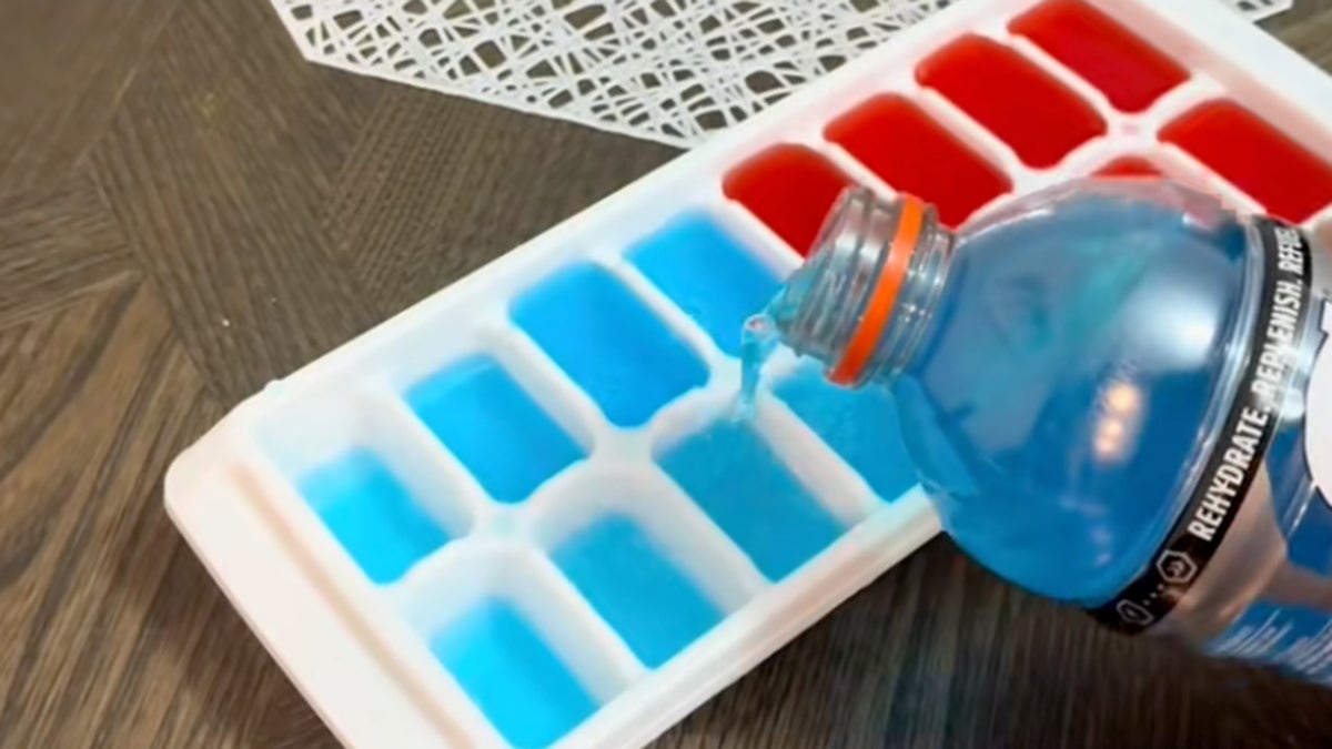 TikToker pouring blue Gatorade into ice cube tray, half of which is filled with red Gatorade.