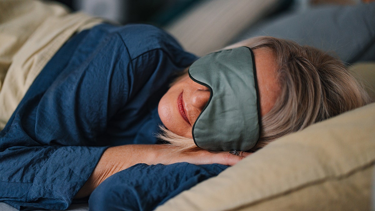Close up shot of older woman sleeping with her eyes covered with a mask