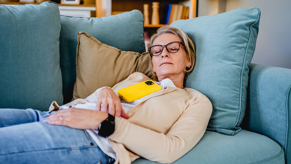 Tired woman taking a nap on the sofa in the living room