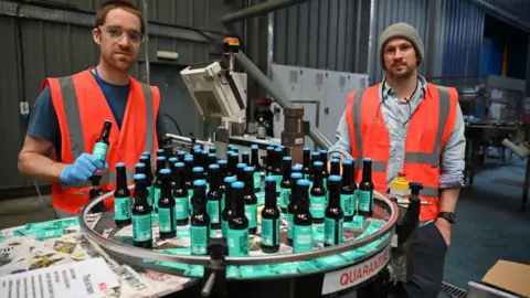 Getty Images Martin Dickie and James Watt (right) pictured packing BrewDog hand sanitizer during the Covid pandemic in April 2020