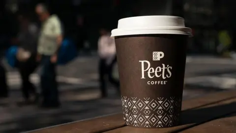 Bloomberg/Getty Images A brown paper cup of Peet's coffee on a picnic table in Washington, DC, US, on Monday, Aug. 25, 2025