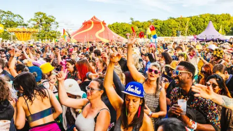 George Harrison A crowd of people dancing at Shambala Festival on a summer day.
