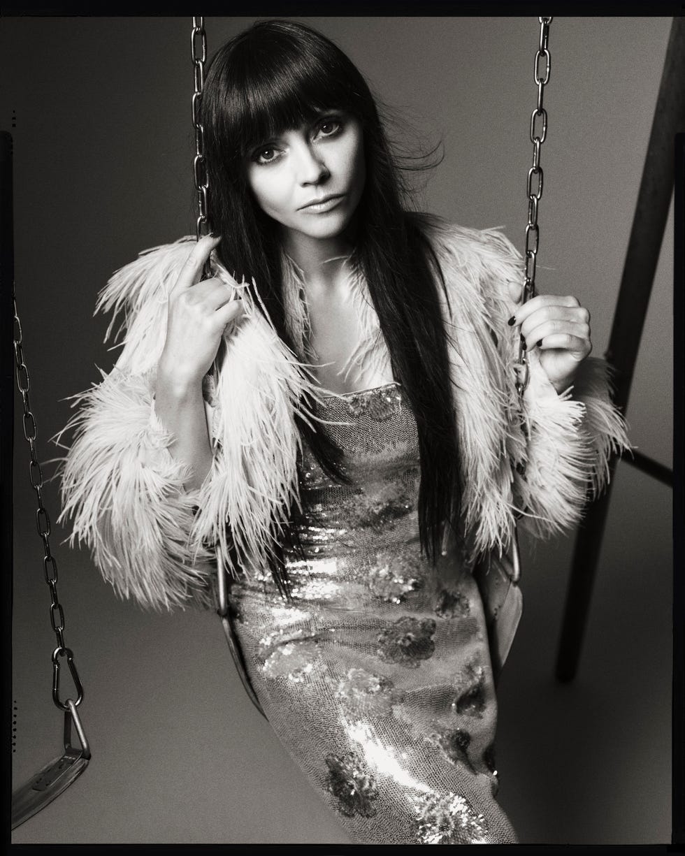 a figure on a swing dressed in a glamorous outfit