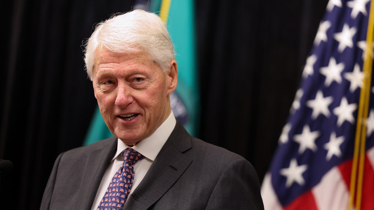 Bill Clinton standing in front of American flag