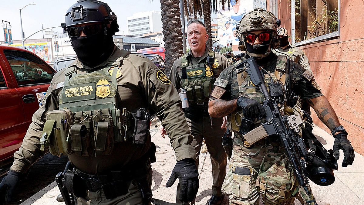 Gregory Bovino, Chief Patrol Agent of the El Centro Sector and Commander-Operation At Large CA (center), marches with federal agents to the Edward R. Roybal Federal Building after US Border Patrol agents produced a show of force outside the Japanese American National Museum where Gov. Newsom was holding a redistricting press conference.