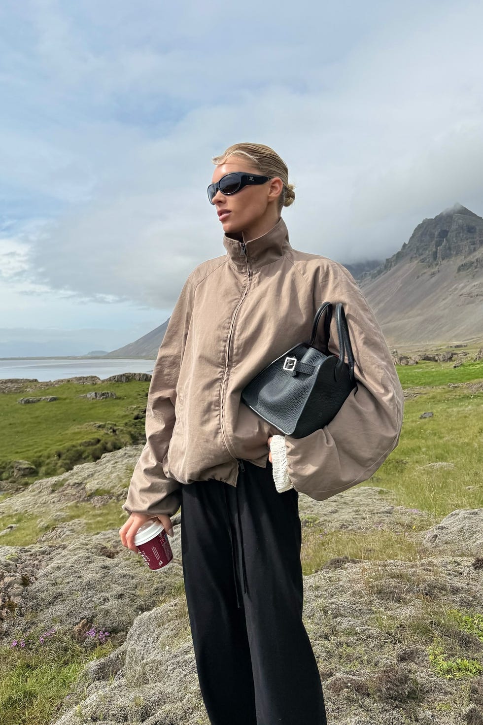 person standing in a landscape with mountains and greenery