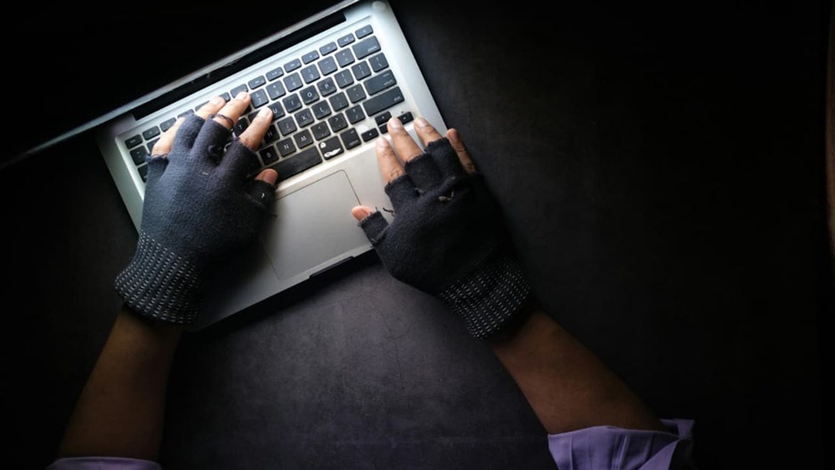 A hacker uses a laptop in to steal data.