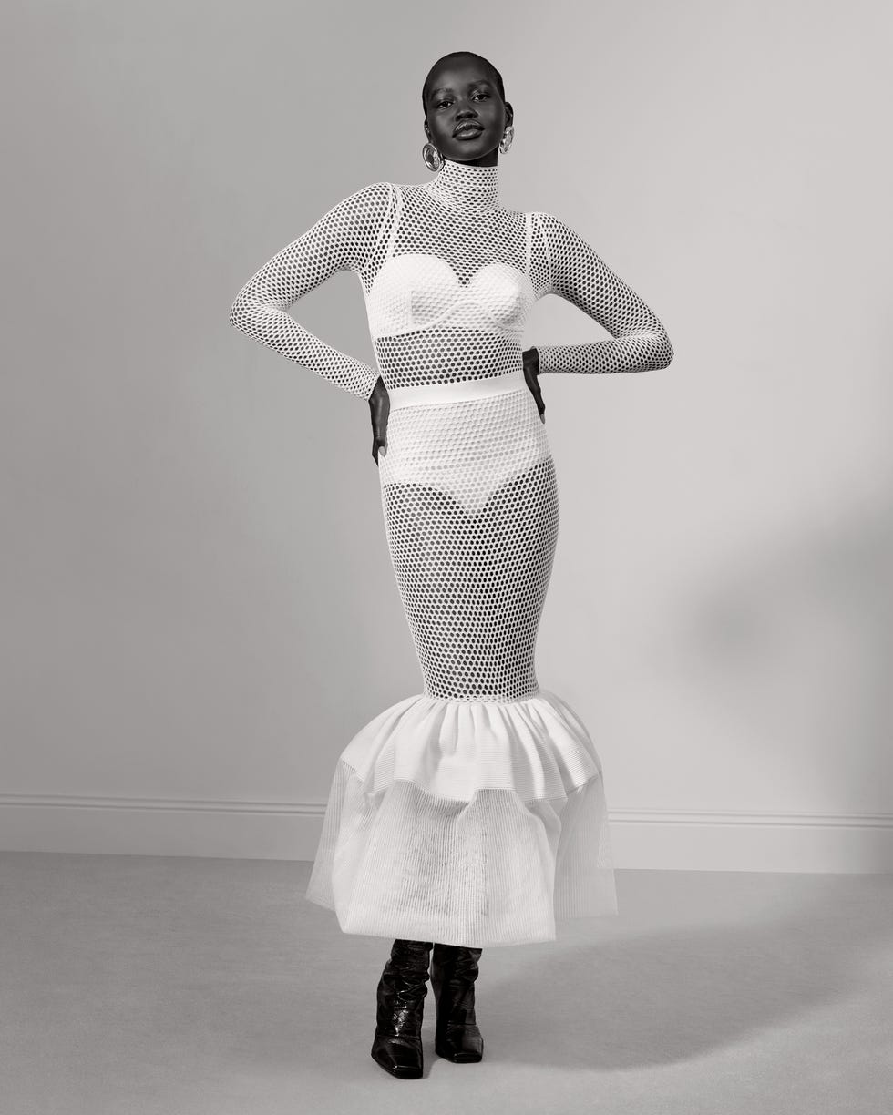 fashion model wearing a unique white mesh dress with a dramatic flared skirt