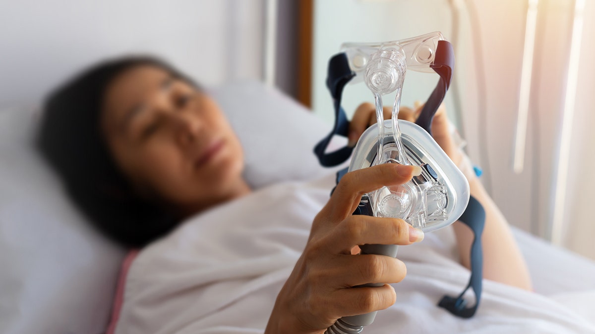 woman holds cpap mask